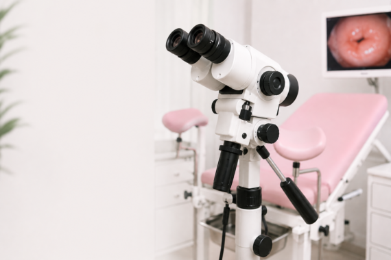 Kolposkop używany w gabinecie ginekologicznym podczas badania kolposkopowego służącego do diagnostyki patologii szyjki macicy. W tle na ekranie monitora widoczna szyjka macicy.